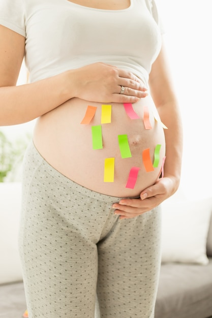Adesivi colorati in primo piano sulla pancia della donna incinta