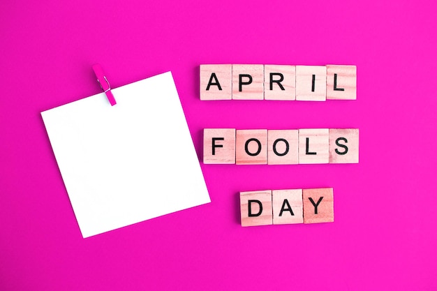 Adesivo con mockup per testo e iscrizione April Fools Day realizzato da cubi di legno su sfondo rosa