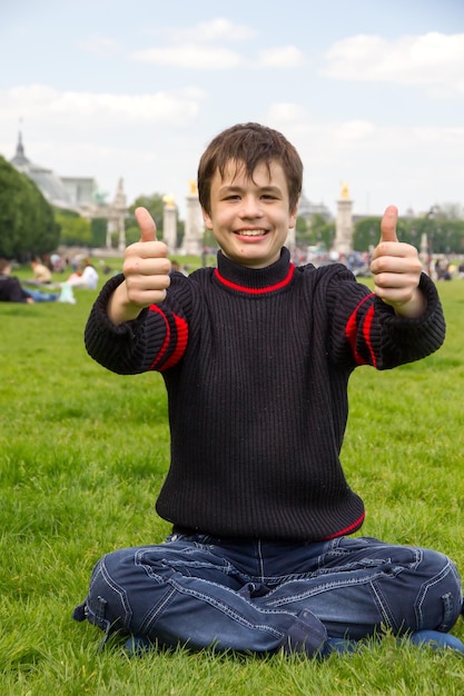 Adolescente allegro mostra il pollice in su sull'Esplanade des Invalides