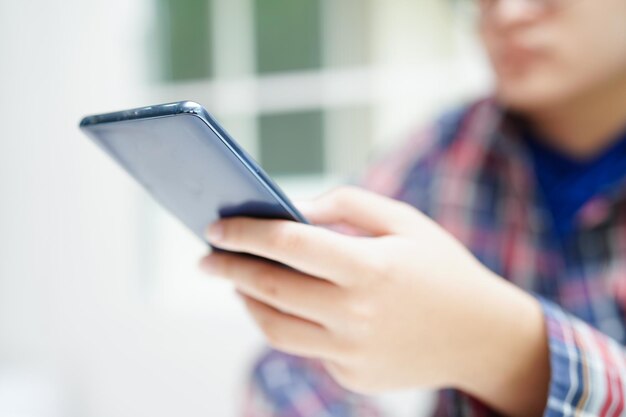 Adolescente asiatico che utilizza l'applicazione mobile nella tecnologia degli smartphone digitali per l'apprendimento