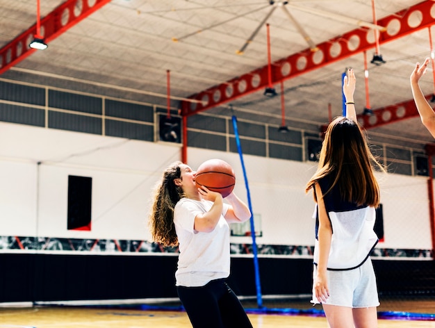 Adolescente che gioca una pallacanestro facendo un passaggio