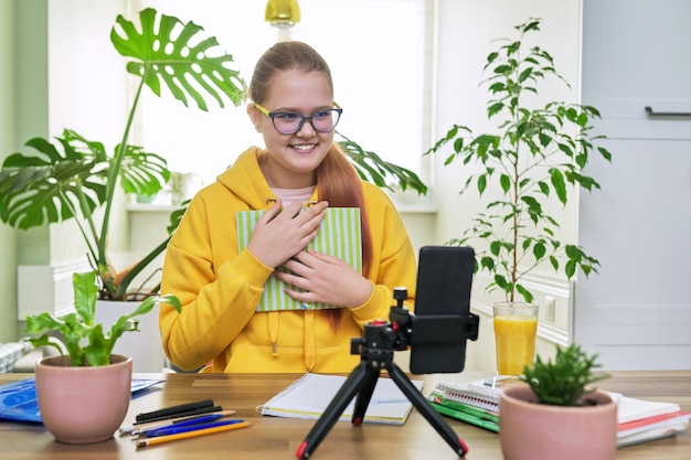 Adolescente che guarda la webcam utilizzando uno smartphone per una lezione online