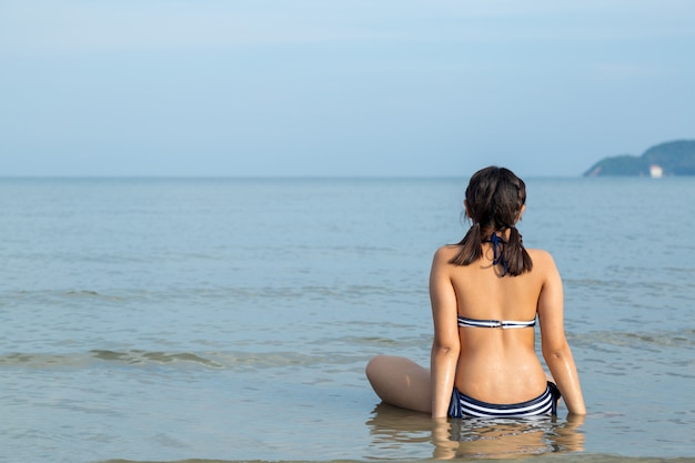 Adolescente che indossa bikini in spiaggia.