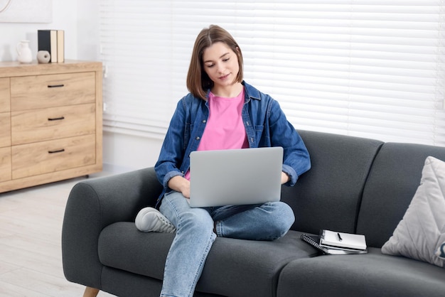 Adolescente che lavora con il portatile a casa Lavoro a distanza