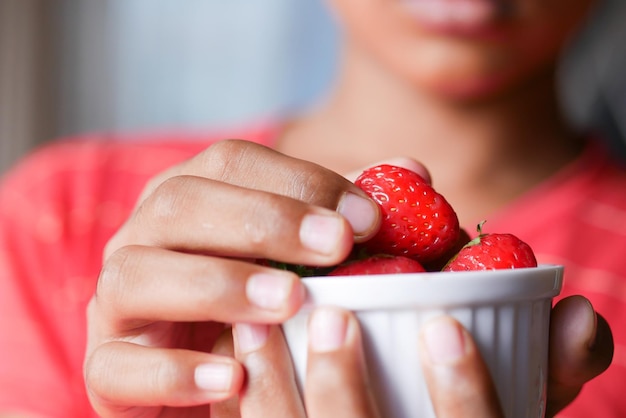 Adolescente che mangia la frutta della fragola