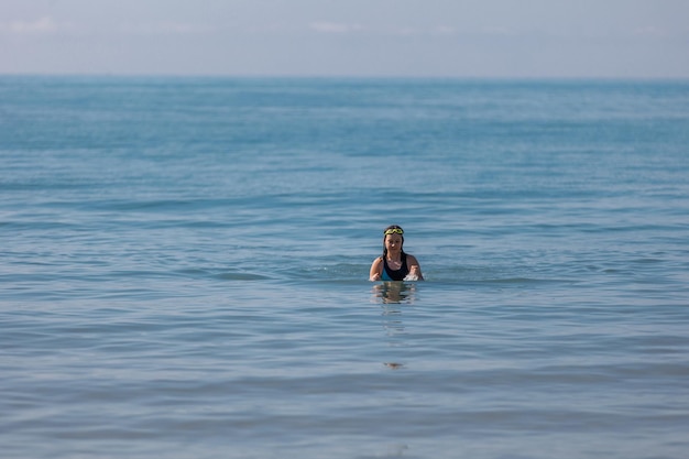 Adolescente che nuota in acqua di mare