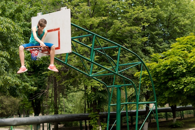 Adolescente che ripara una rete da basket