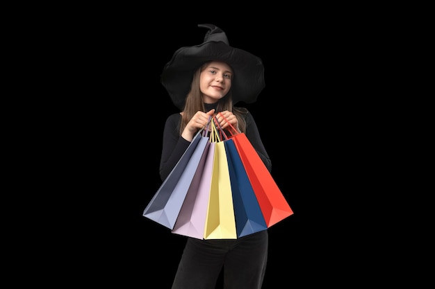 Adolescente con cappello nero con borse della spesa multicolori Isolamento su sfondo nero Spazio di copia Black Friday Concept