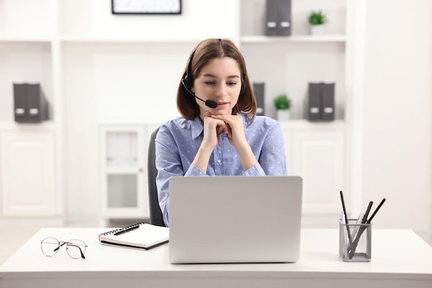 Adolescente con le cuffie che fa video chat tramite laptop a casa Lavoro a distanza