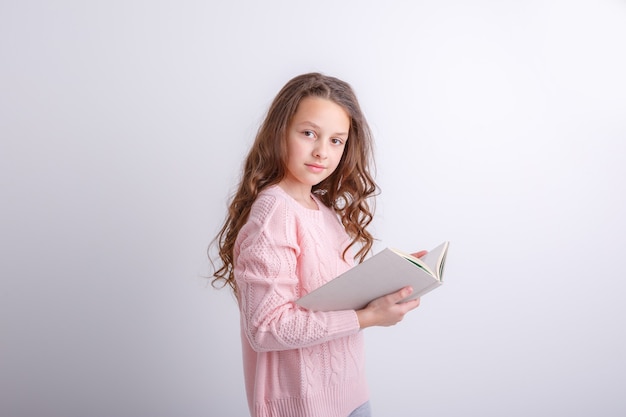 Adolescente con un libro in mano su uno sfondo bianco Mostra emozioni gioia sorpresa tristezza