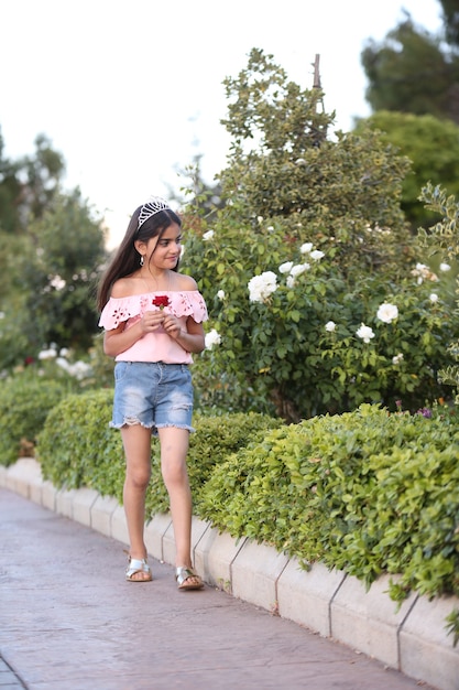 Adolescente della bambina che cammina sul campo con lo stile di vita dei fiori sulla natura