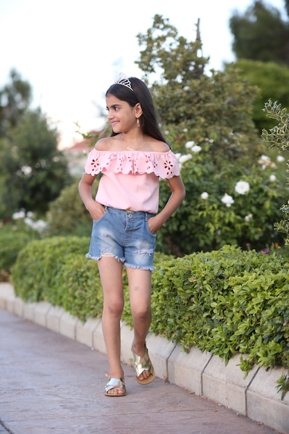 Adolescente della bambina che cammina sul campo con lo stile di vita dei fiori sulla natura