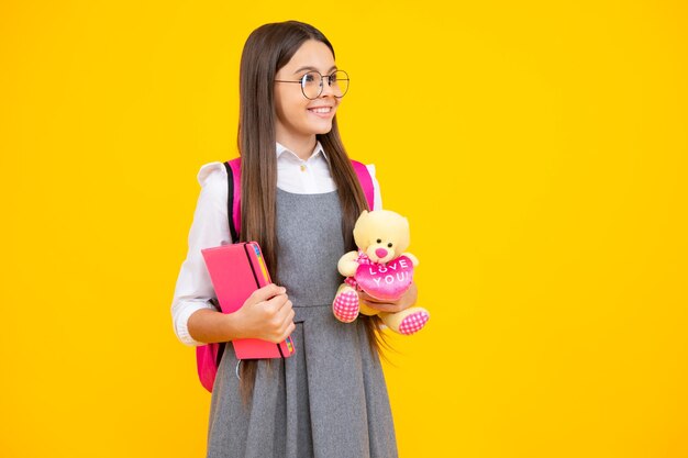 Adolescente della scuola ragazza con libro e zaino tenere giocattolo Studio divertente Istruzione e concetto di infanzia