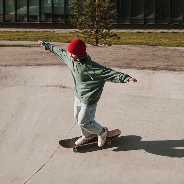 Adolescente divertirsi con lo skateboard allo skatepark