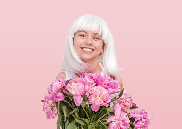 Adolescente felice in parrucca che porta fiori