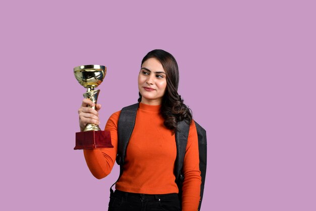 Adolescente felice studente ragazza con trofeo d'oro indiano modello pakistano