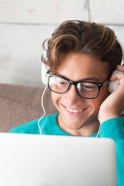 Adolescente giovane e allegro felice in videoconferenza chat su computer portatile a casa lockdown o studente con tecnologia internet intelligente che studia con un dispositivo moderno non a scuola vita online