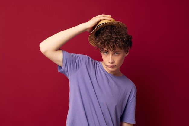 Adolescente in magliette viola cappello in posa emozioni sfondo rosso inalterato