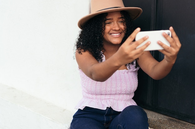 Adolescente latina che si fa un selfie con il telefono