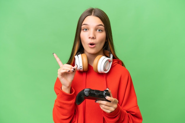 Adolescente ragazza caucasica che gioca con un controller per videogiochi su sfondo isolato con l'intenzione di realizzare la soluzione sollevando un dito