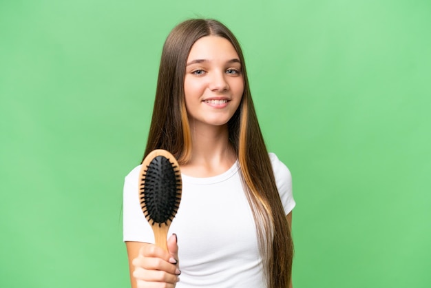 Adolescente ragazza caucasica con pettine per capelli su sfondo isolato con felice espressione