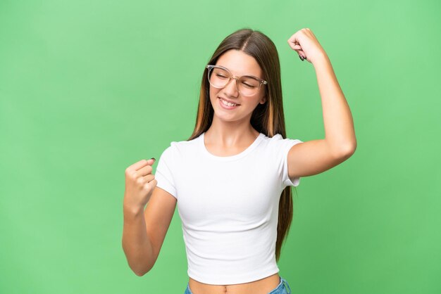 Adolescente ragazza caucasica su sfondo isolato che celebra una vittoria