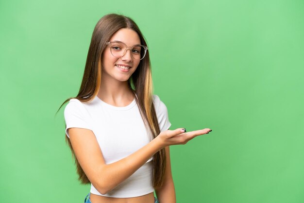 Adolescente ragazza caucasica su sfondo isolato che presenta un'idea guardando sorridente verso