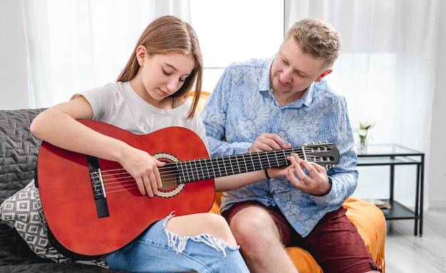 Adolescente ragazza che si esercita a suonare la chitarra