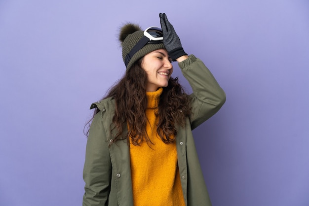 Adolescente ragazza russa con occhiali da snowboard isolati su sfondo viola ha realizzato qualcosa e intende la soluzione