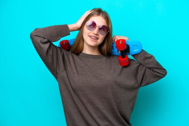 Adolescente ragazza russa isolata su sfondo blu con un pattino e alzando lo sguardo