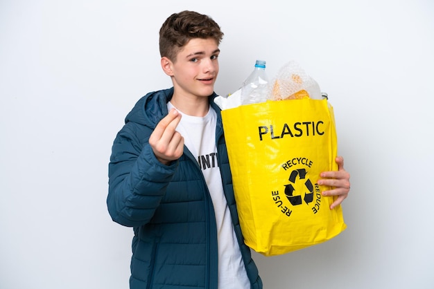 Adolescente russo che tiene un sacchetto pieno di bottiglie di plastica da riciclare su sfondo bianco facendo un gesto di denaro