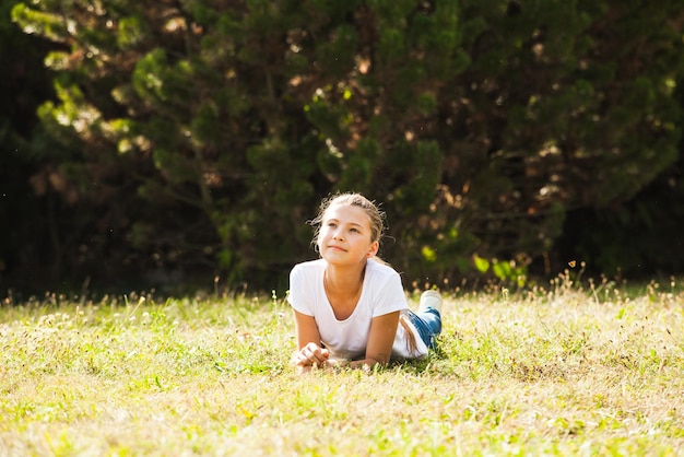 Adolescente sdraiato sull'erba nel parco, tempo libero estivo