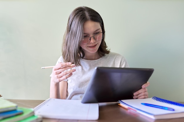 Adolescente studentessa che studia online utilizzando tablet digitale, videoconferenza, videochiamata, istruzione a distanza, apprendimento a casa