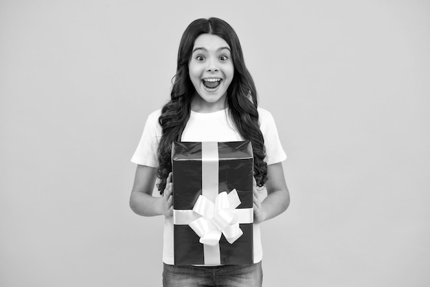 Adolescente stupito Adolescente emotivo bambino tenere regalo per il compleanno Ragazza divertente del bambino che tiene scatole regalo per celebrare il felice anno nuovo o Natale Ragazza adolescente eccitata