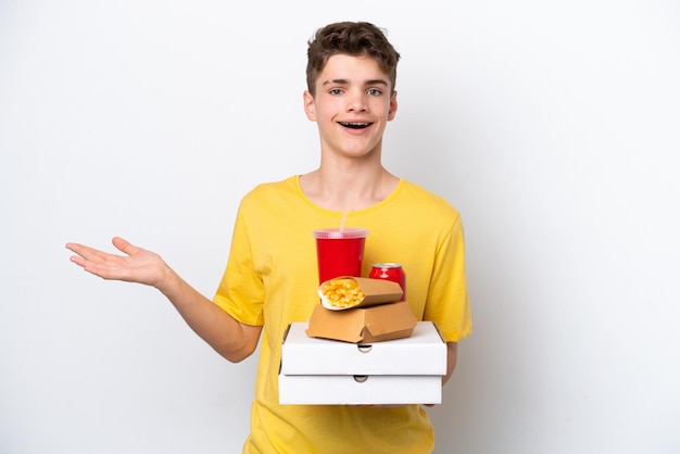 Adolescente uomo russo azienda fast food isolato su sfondo bianco con espressione facciale scioccata