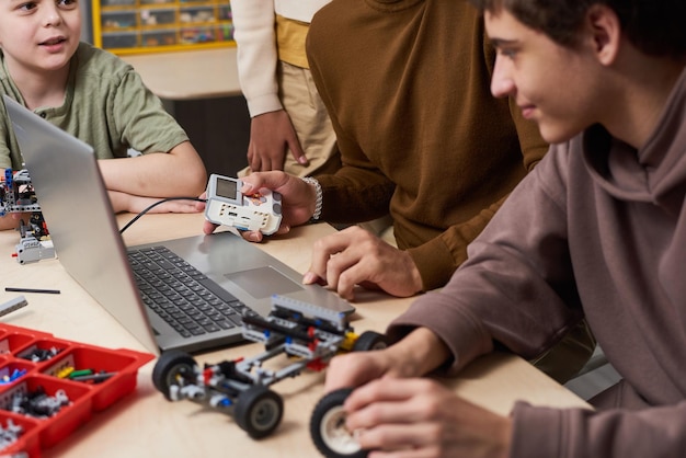 Adolescenti che usano il laptop alla lezione di robotica