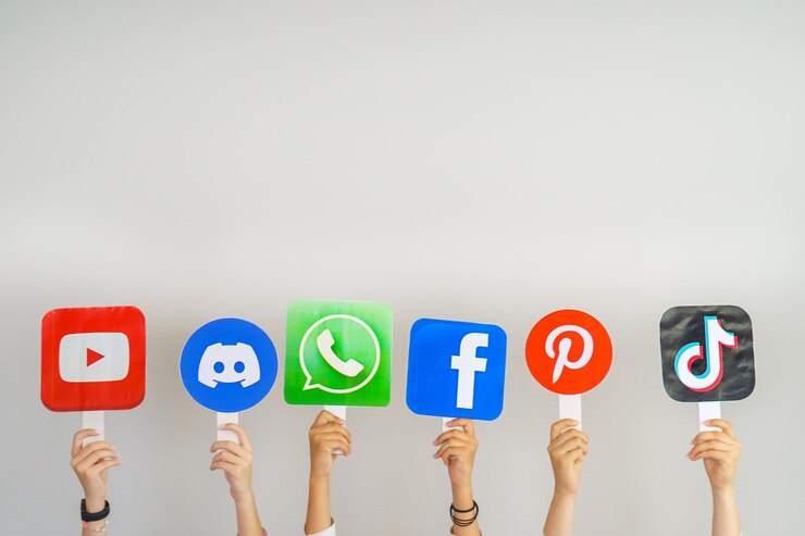 Adolescenti con cartelli con i loghi di YouTube Discord WhatsApp TikTok Facebook Pinterest