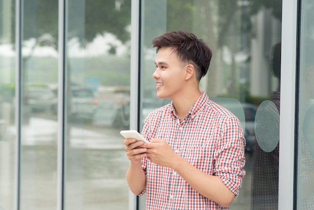 Adolescenti con il telefono cellulare fuori dall'edificio in città