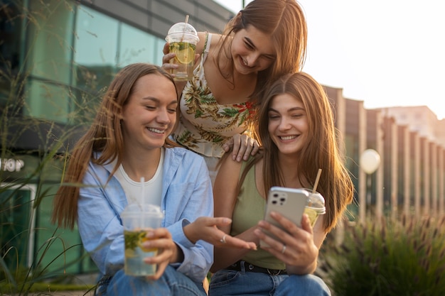 Adolescenti di smiley di vista frontale con lo smartphone