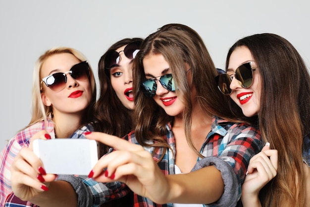 Adolescenti felici con smartphone che prendono selfie