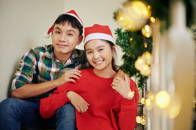 Adolescenti felici in cappelli di Babbo Natale