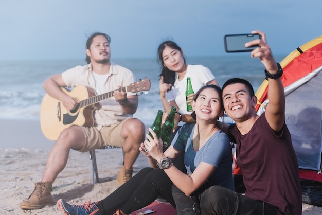 Adolescenti in un campeggio, prendendo un selfie usando uno smartphone