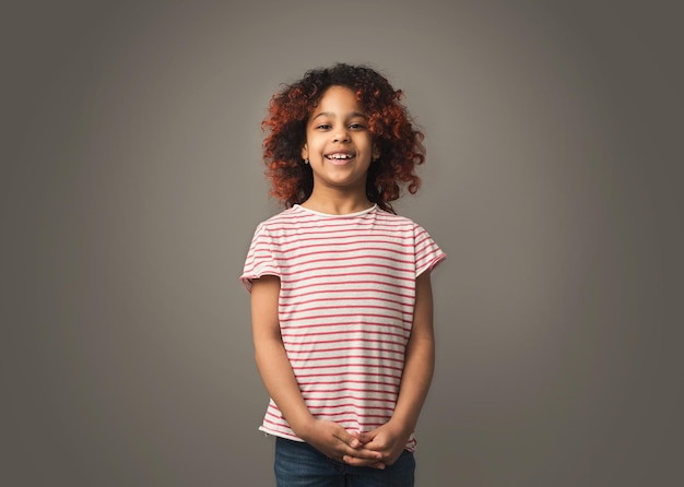 Adorabile bambina africana con bella acconciatura su sfondo gary studio