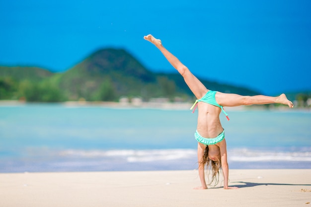 Adorabile bambina attiva in spiaggia durante le vacanze estive