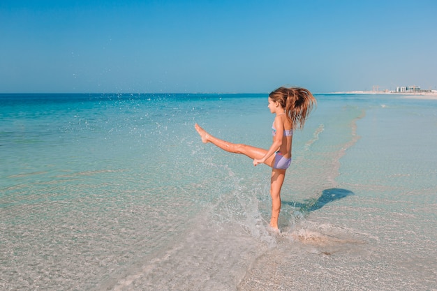 Adorabile bambina attiva in spiaggia durante le vacanze estive