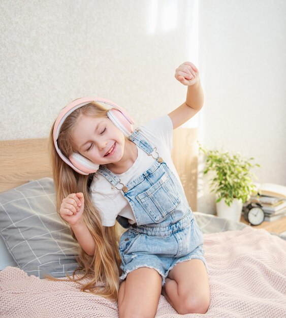 Adorabile bambina in cuffia si diverte con una musica