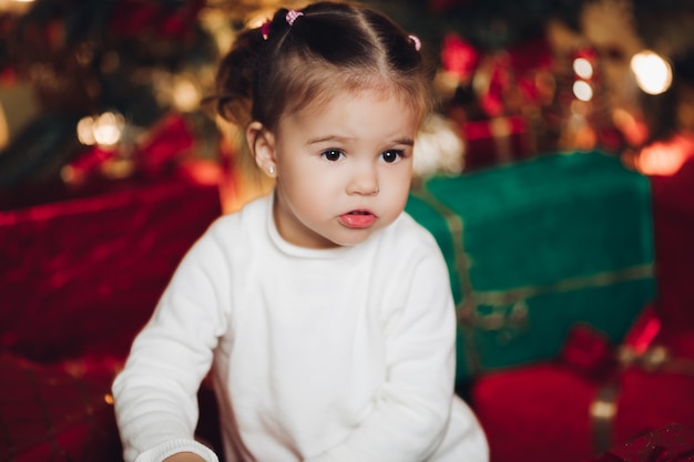 Adorabile bambina in regali di Natale. sala decorata per Natale.