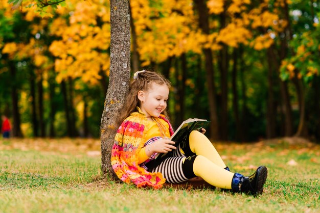 Adorabile bambina in un bellissimo parco autunnale