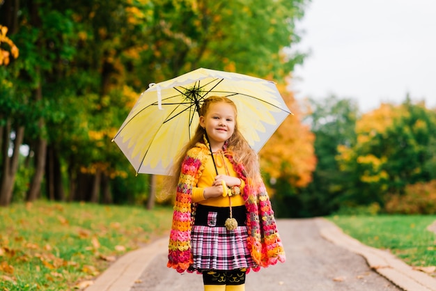 Adorabile bambina in un bellissimo parco autunnale