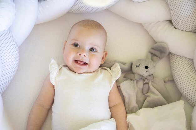 Adorabile bambina sorridente con un coniglietto giocattolo